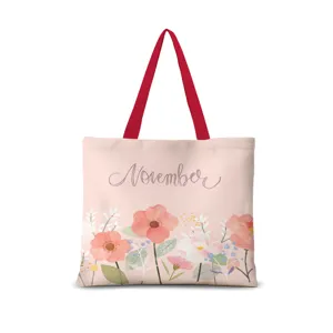 Vue détaillée du sac cabas en toile rose avec motif floral aquarelle et inscription November.