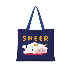 Vue détaillée du sac cabas en toile bleu foncé avec un dessin animé de mouton et texte jaune.