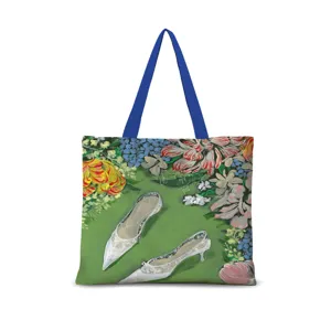 Détail de sac cabas en toile avec illustration florale vintage et poignée bleue quotidienne.