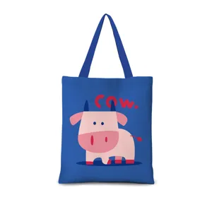 Vue détaillée du sac cabas en toile bleue avec un joli imprimé de vaches roses et texte.