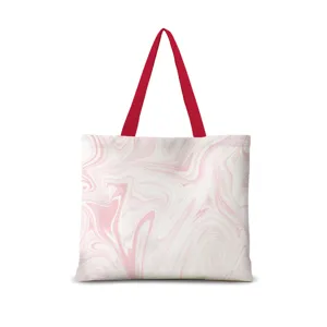 Gros plan détaillé du sac cabas en toile à motif marbre rose et blanc avec anses rouges.