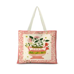Gros plan détaillé du motif artistique de vase de fleurs et de la bordure en dentelle sur le sac cabas.