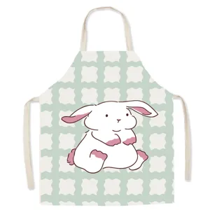 Close up of cotton linen kitchen apron with cute cartoon rabbit print and green grid.
