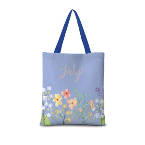 Vue détaillée du sac cabas en toile bleue avec joli imprimé floral et texte july.