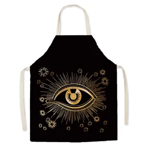 Detailed view of the black canvas apron featuring a golden mystic eye and stars print.