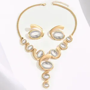 Trendy exaggerated gold-tone statement necklace and earrings set with grey oval stone details.