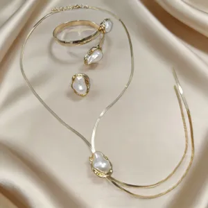 Detail view of a chic French baroque pearl necklace bracelet and ring set in gold.
