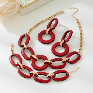 Red wood grain and gold geometric link jewelry set detail, stylish statement accessories.