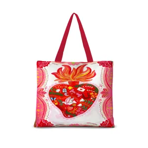 Détail de sac cabas en toile imprimé cœur sacré, avec anses rouges et illustration artistique.