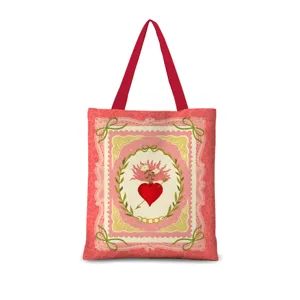 Vue rapprochée détaillée du sac cabas en toile vintage au cœur sacré, poignées rouges et dentelle.