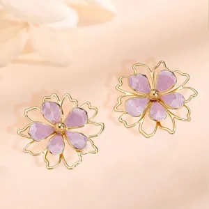 Close-up detail of the purple enamel hollow double-layer flower earrings, shiny gold finish.