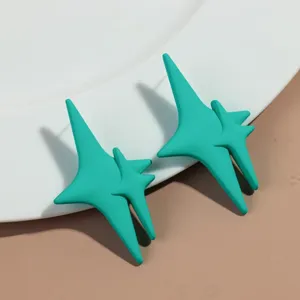 Close-up detail of vibrant turquoise asymmetric multi-point star stud earrings, stylish daily wear.
