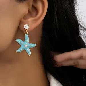 Detailed close-up of a blue enamel starfish dangle earring with rhinestone and pearl.