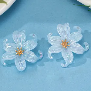 Clear acrylic iridescent flower earrings detail view showing lovely petal shine and gold center.
