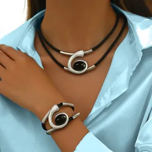 Close-up detail of bohemian style spiral gemstone necklace and matching bracelet jewelry set.