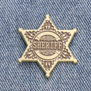 Broche insignia de sheriff de metal en forma de estrella estilo western retro primer plano.