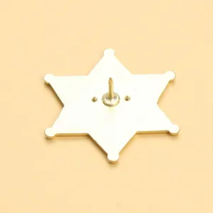 Close-up detail of the metal reverse side and pin of a vintage western star badge.