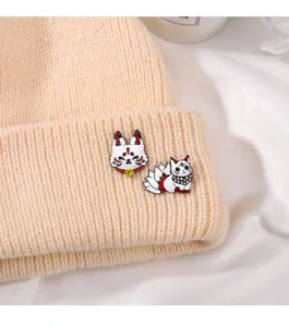 Beige knit beanie hat featuring cute Japanese kitsune nine-tailed fox enamel pins set for decor.