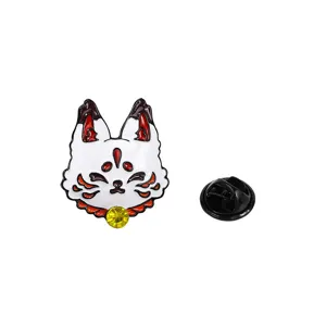 Close-up detail shot of the cute white fox enamel pin with red details and sparkling yellow gem.