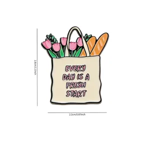 Detailed view of the cute shopping bag enamel pin featuring tulips, baguettes and inspiring text.