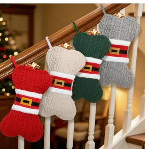 Vue détaillée de bas de Noël colorés en tricot en forme d'os suspendus sur une rampe.