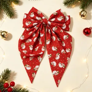 Vue détaillée de la pince à cheveux nœud rouge imprimé Père Noël et déco de fête.