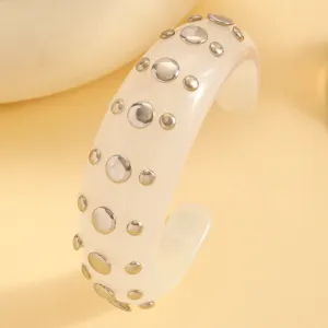Close-up view of the chic resin cuff bracelet featuring metallic studded details, wide style.