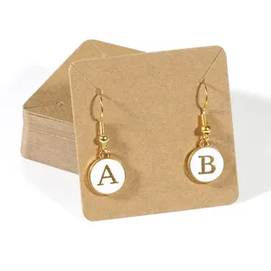 Letter A and B initial charm dangle earrings on kraft paper display cards for jewelry.