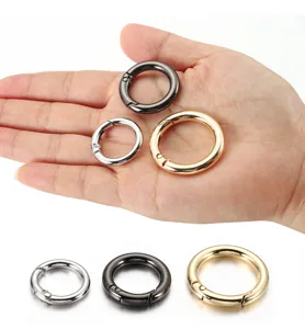 Close-up detail shot of round metal spring snap hooks in various sizes and metallic finishes.