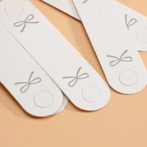 Schleife Haargummi Verpackungskarte Detail, weißes gefaltetes Papier für Schmuck.