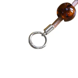 Round metal spring ring clasp with leather strap and amber bead for DIY jewelry making crafts.