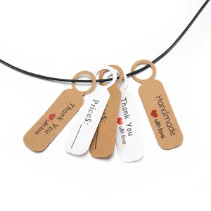 Close-up detail of kraft paper thank you and price tags hanging on a black cord for jewelry.