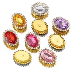 Gros plan sur les strass ovales à coudre, monture dorée avec bordure de pierres brillantes.