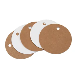 Close up detail of blank round kraft and white paper hang tags with hole for DIY gift packaging.