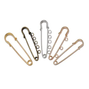 Detailaufnahme von Sicherheitsnadeln mit Schlaufen, verschiedene Metallfarben für DIY Basteln.