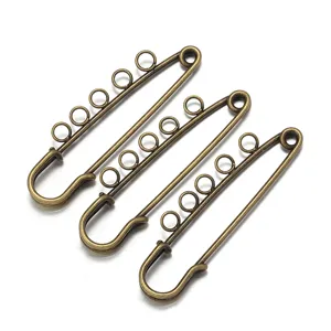 Detailaufnahme antiker bronzener Sicherheitsnadeln mit Schlaufen für DIY Schmuck Zubehör.