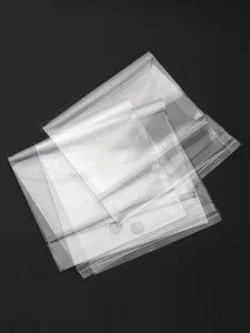 Detail shot of transparent self-adhesive OPP plastic packaging bags showing seal strip details.