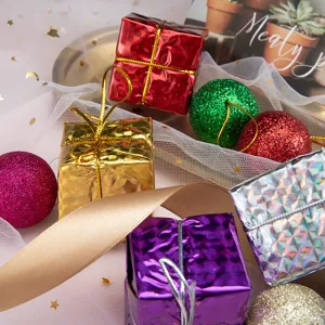 Vista detallada de mini cajas de regalo de Navidad y adornos colgantes de bolas brillantes.