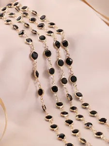 Primo piano catena metallica dorata con strass neri, perfetta per creazione di gioielli fai da te.