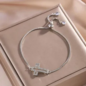 Gedetailleerd dichtbijzicht van een elegante zilveren verstelbare armband met kruis.