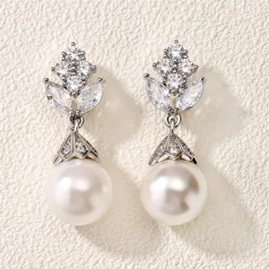 Detailopname van prachtige zilveren oorbellen met fonkelende zirkonia's en elegante parels.