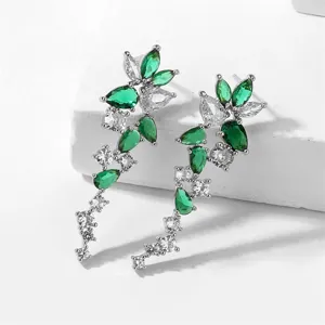 Gedetailleerde close-up van lange cascade oorbellen met groene en heldere zirkonia.