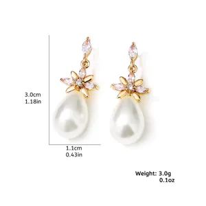 Elegante vergulde bloem hangende oorknoppen met sprankelende zirkonia en witte parels.