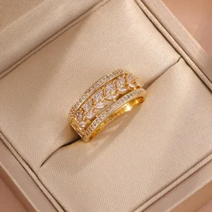 Gedetailleerde close-up van een luxe ring met zirkonia en een korenbladig opengewerkt design.