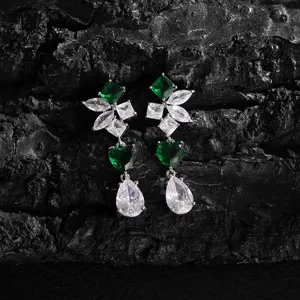 Gedetailleerde close-up van lange hangende oorbellen met groene en witte zirkonia.