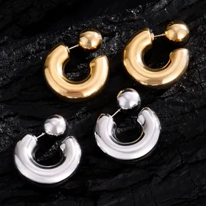 Gedetailleerde opname van chunky C-vormige baloorringen in goud en zilver met modern design.