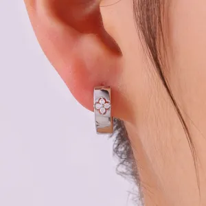 Close-up van een delicate metalen oorring met een prachtig zirkonia bloemmotiefje.