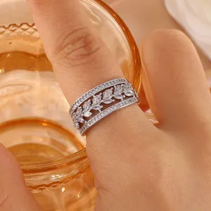 Gedetailleerde close-up van drielaagse zirkoonring met hol bladdesign voor dames.