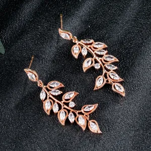 Delicate roségouden bladvormige oorbellen met fonkelende zirkonia stenen detailopname.