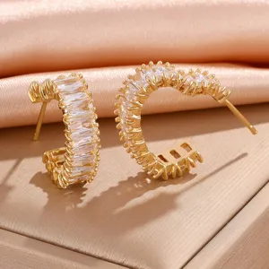 Elegante vergulde C-vormige creolen met sprankelende baguette zirkonia stenen.